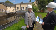 Zwei envia THERM-Mitarbeiter vor einem Wasserbecken und Gebäudeteilen der Wasserkraftanlage Frankenberg Zwei envia THERM-Mitarbeiter vor einem Wasserbecken und Gebäudeteilen der Wasserkraftanlage Frankenberg