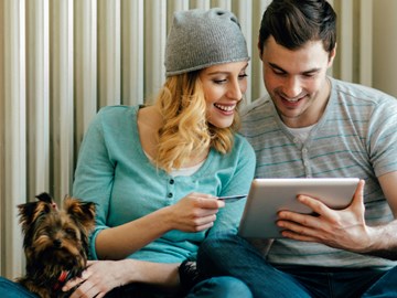 Mann und Frau sitzen mit Hund vor einem Heizkörper Mann und Frau sitzen mit Hund vor einem Heizkörper